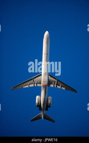 SAS McDonnell Douglas MD-90 climbing out after take-off with flaps deployed and rotating beacon flashing between wings Stock Photo