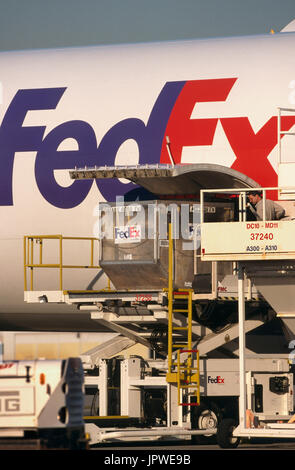 LD3 containers being loaded into lower side cargo door of a FedEx Airbus A300-600 freighter Stock Photo