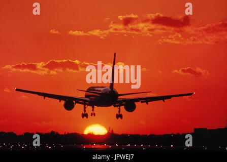 Boeing 757 landing on the runway with runway-lights on at sunset Stock Photo