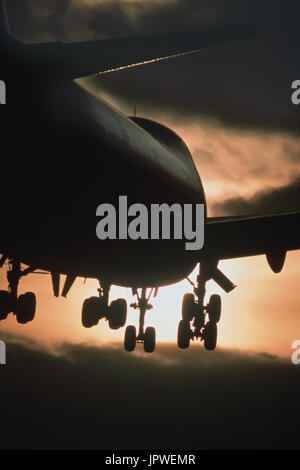 Boeing 747 on final-approach at dusk with undercarriage down and dark-clouds Stock Photo