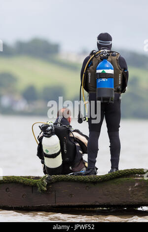 Two scuba divers prepare to enter the water Stock Photo