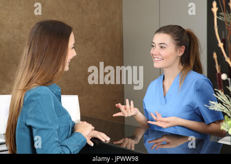 Happy dentist or nurse attending a patient in a consultation Stock Photo