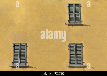 Closed green windows on yellow wall of old house in Florence city, Italy Stock Photo