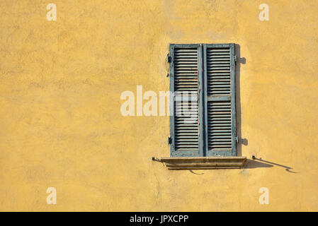 Closed green windows on yellow wall of old house in Florence city, Italy Stock Photo