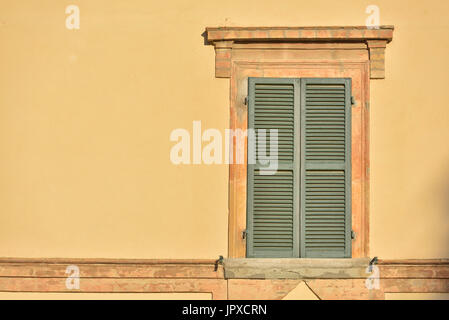 Closed green windows on yellow wall of old house in Florence city, Italy Stock Photo