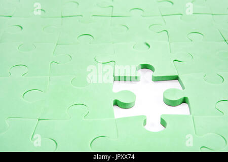 Folded green puzzle with a hole instead of without one element Stock Photo