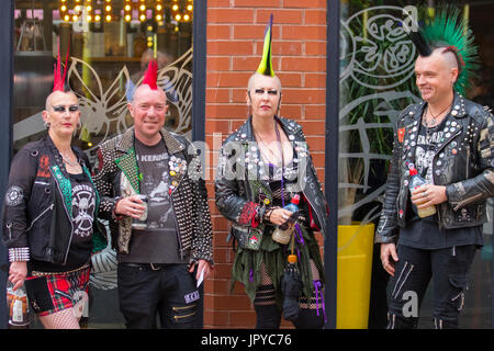 Punk rockers with dyed liberty spiked hair Blackpool, UK. . Rebellion Festival world's largest punk festival begins as thousands of punks arrive in Blackpool for international punk rock alternative music festivals. At the beginning of August, Blackpool’s Winter Gardens plays host to a massive line up of bands, fans & mohawk-sporting rockers for the 21st edition of Rebellion Festival, clad in emblazoned leather jackets and plaid trousers. There’s a fringe fest running alongside the main event with fashion items, music cd’s, piercing, tattoos,and alternate entertainment for gig-goers. Stock Photo