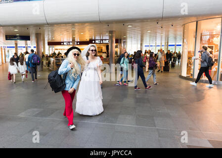 Two young women in fancy dress walking through King's Cross Station with other commuters, London, UK. 3rd August, 2017. Stock Photo