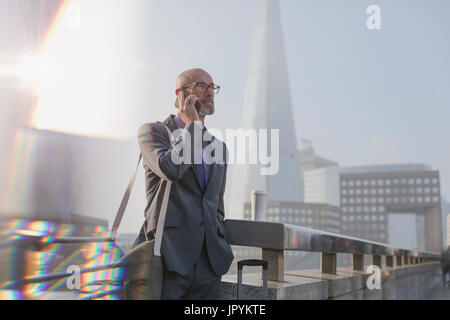 Businessman talking on cell phone on bridge, London, UK Stock Photo