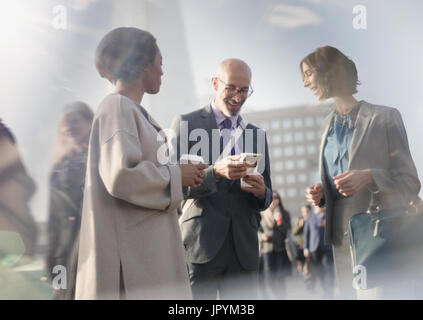 Business people talking, using cell phone and drinking coffee on urban street Stock Photo