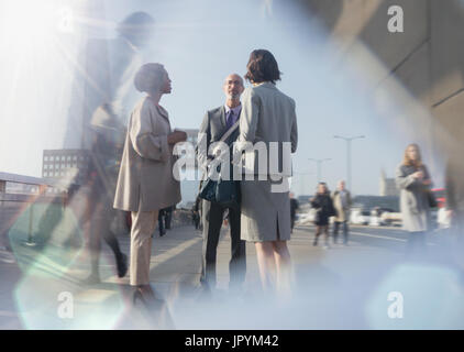 Business people talking on sunny urban street Stock Photo