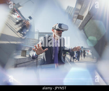 Businessman using virtual reality simulator glasses on urban bridge Stock Photo