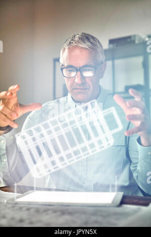 Male architect performing telekinesis, hovering futuristic glowing plastic model Stock Photo