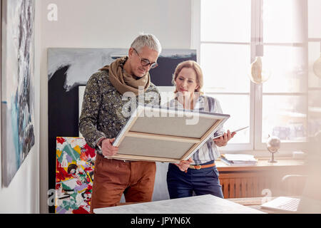 Painters examining painting in art studio Stock Photo