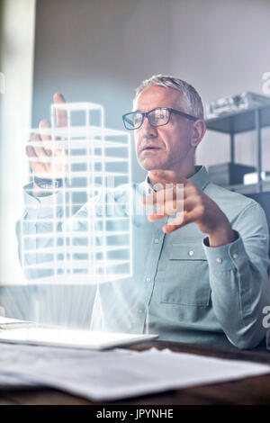 Male architect performing telekinesis, hovering futuristic glowing plastic model Stock Photo