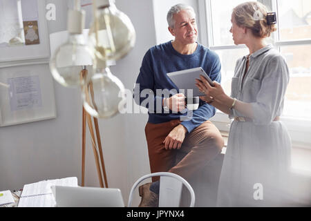 Business people drinking coffee and using digital tablet in office meeting Stock Photo