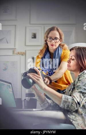 Female photographers using digital camera in office Stock Photo