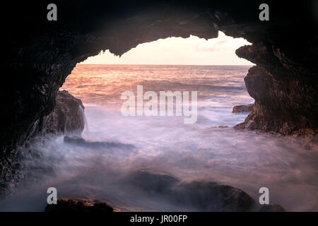 HI00312-00...HAWAI'I - Sunrise over the Pacific Ocean viewed through a natural bridge along the Kaimu-Kapoho Road (Red Road) on the island of Hawai'i. Stock Photo