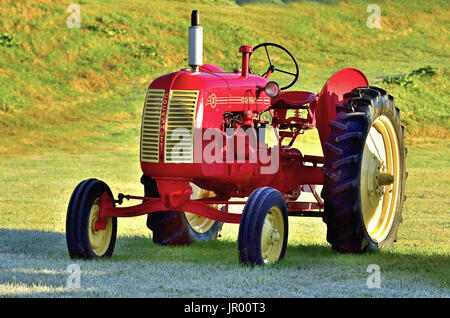 A red Cockshutt farm tractor restored to its original condition parked in a farm field on a fall morning in New Brunswick Canada Stock Photo