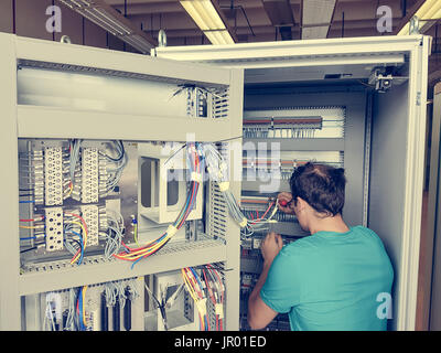 Electrical engineer configuring wires. Stock Photo