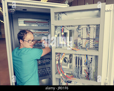 Electrical engineer configuring wires. Stock Photo