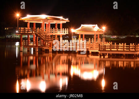 Chinese style pavilion and glowing reflection on the water of Dahu Park lake at night in Taipei, Taiwan Stock Photo