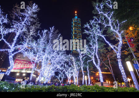 TAIPEI, TAIWAN - DECEMBER 23, 2016 - Christmas lights glow in front of the Taipei 101 building at night in the Xinyi Anhe district of Taiwan's capital Stock Photo