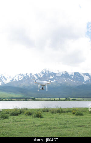 Man controling a drone on mountain background. Stock Photo