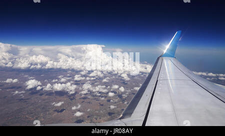 Flying over the clouds. View from plane aircraft. Stock Photo