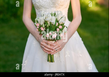 bride is holding a wedding bouquet of flowers Stock Photo