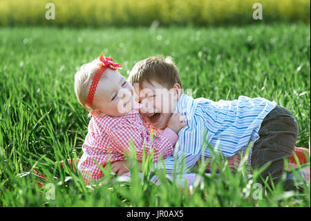 Little children boy and girl play on green grass Stock Photo