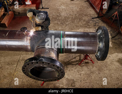 A Welder Works On Welding The Joints Of Pipes; Edmonton, Alberta, Canada Stock Photo