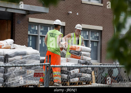 Construction workers mixing cement Stock Photo