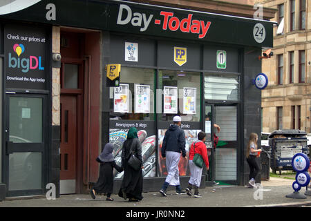 Asian family refugee dressed Hijab scarf on street in the UK everyday scene Govanhill Glasgow Stock Photo