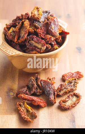 Dried sliced tomatoes in bowl on wooden table. Tomatoes as superfood. Stock Photo