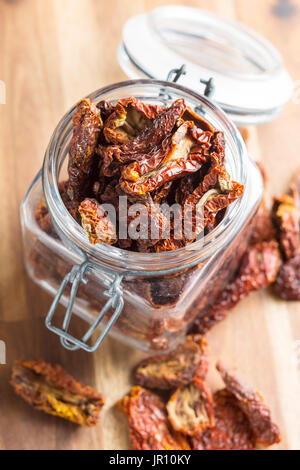 Dried sliced tomatoes in jar on wooden table. Tomatoes as superfood. Stock Photo