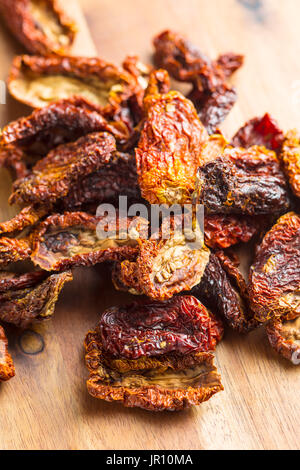 Dried sliced tomatoes on wooden table. Tomatoes as superfood. Stock Photo