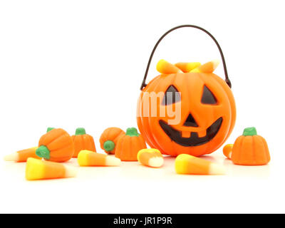 Halloween Jack o Lantern collector and a pile of scattered candies over white Stock Photo