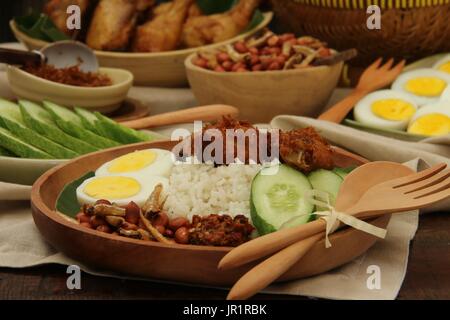 Nasi Lemak, Malaysian Savory Rice Dish with Fried Chicken, Egg, Peanuts, Anchovies, and Chili Paste Stock Photo