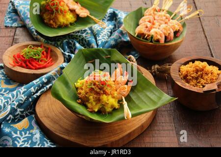 Ketan Serundeng Udang. Turmeric Sticky Rice with Roasted Coconut and Shrimp Satay Stock Photo