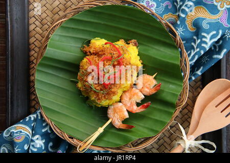 Ketan Serundeng Udang. Turmeric Sticky Rice with Roasted Coconut and Shrimp Satay Stock Photo