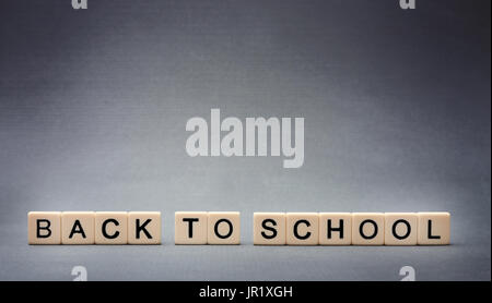Back to School spelled out in tiles on a grey background Stock Photo