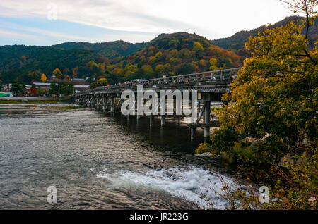 KYOTO, JAPAN - NOVEMBER 18, 2016 - Fall color attracts visitors to the Togetsu Bridge on the Katsura River in the Arashiyama area of Kyoto, Japan Stock Photo