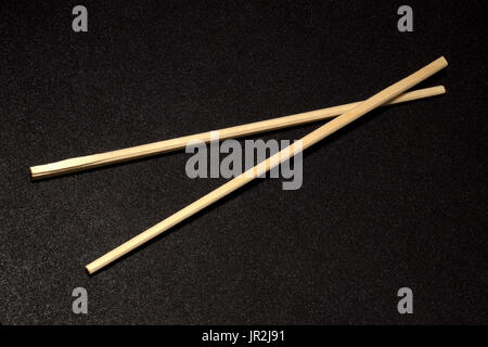 A set of disposable chopsticks on a black background. Part of a continuing series of experimenting with improvised lighting and close-up shots. Stock Photo