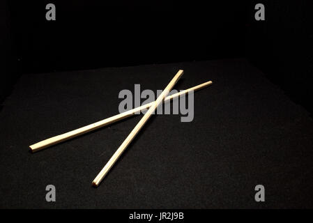 A set of disposable chopsticks on a black background. Part of a continuing series of experimenting with improvised lighting and close-up shots. Stock Photo
