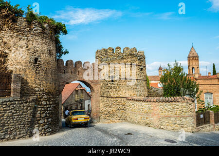 An Old Soviet Car Driving Through The Arch In The Remnants Of 18th Century Fortifications And Watchtowers; Sighnaghi, Kakheti Region, Georgia Stock Photo