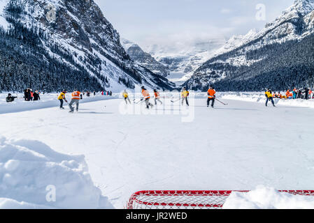 A Pair Of Hockey Teams Compete In Pond Hockey On Lake Louise At The Fairmont Chateau Lake Louise Pond Hockey Tournament In The Winter Stock Photo