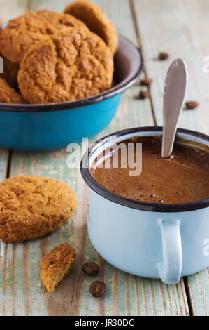 coffee in a metal mug on the old blue wooden background with grains with oatmeal cookies Stock Photo
