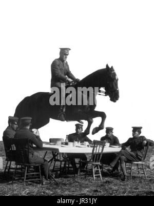 US Army men seated around table, with one on horseback jumping over the table, Fort Riley, Kansas. The United States Cavalry was the designation of the mounted force of the United States Army from the late 18th to the early 20th century. In 1887, Fort Riley became the site of the United States Cavalry School. The all-black 9th and 10th Cavalry Regiments (Buffalo Soldiers), were stationed at Fort Riley at various times in the 19th and early 20th centuries. During WWI, the fort was home to 50,000 soldiers, and it is sometimes identified as ground zero for the 1918 Spanish flu pandemic, which its Stock Photo