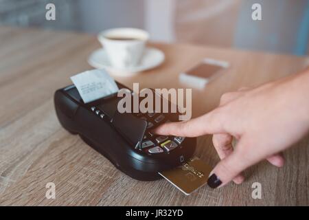 Consument entering pin code on card terminal during payment Stock Photo